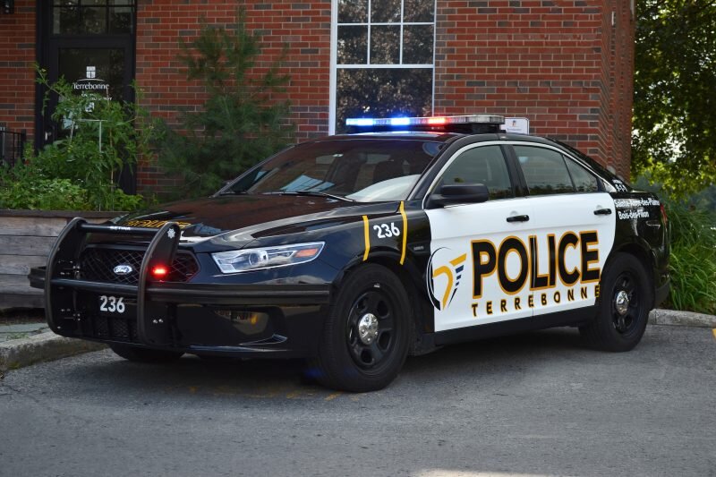 Could contain: land vehicle, vehicle, text, wheel, outdoor, transport, police car, law enforcement, full-size car, vehicle registration plate, emergency service, car, emergency vehicle, ford, ford crown victoria police interceptor, tire, holden ve commodore, street, police