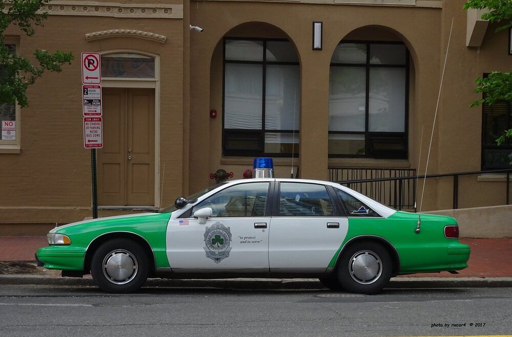 Could contain: vehicle, land vehicle, transport, wheel, outdoor, car, building, full-size car, sedan, police, ford crown victoria police interceptor, police car, mid-size car, road, street, parked