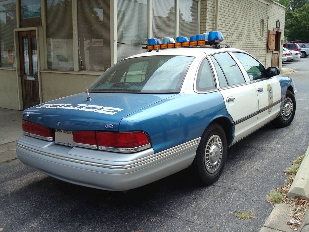 Could contain: land vehicle, vehicle, wheel, outdoor, full-size car, transport, vehicle registration plate, sedan, text, mid-size car, car, tire, ford crown victoria police interceptor, parked, police