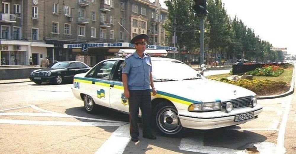 Could contain: vehicle, land vehicle, outdoor, wheel, clothing, law enforcement, transport, police car, emergency service, full-size car, emergency vehicle, person, ford crown victoria police interceptor, vehicle registration plate, ford, emergency, road, street, police, car