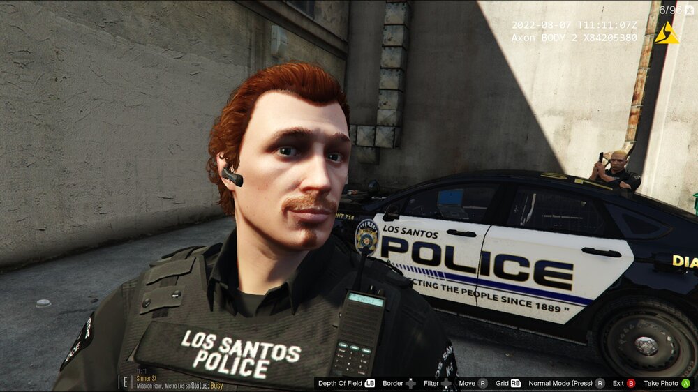 Could contain: text, human face, vehicle, person, car, land vehicle, tire, clothing, wheel, building, auto part, screenshot, officer, police, street, outdoor