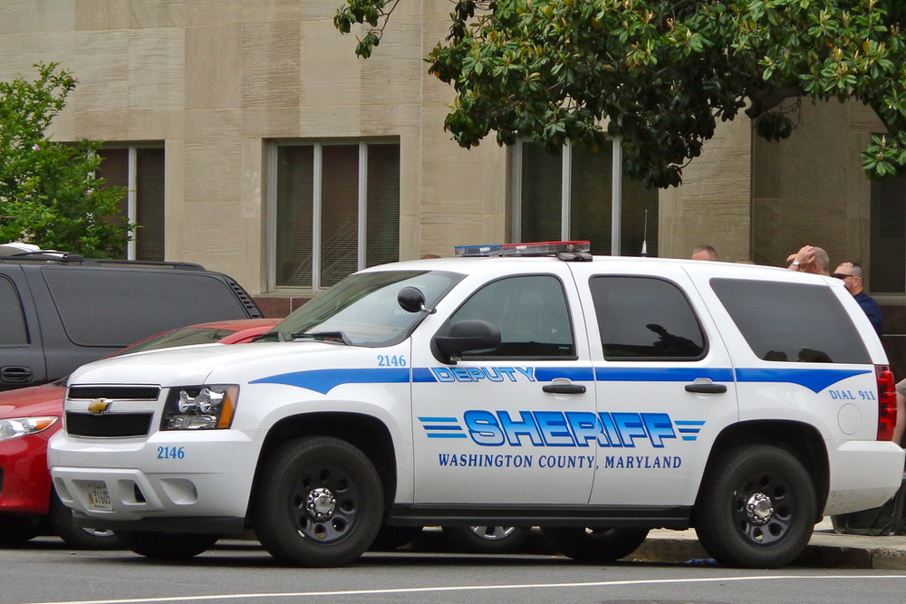 Could contain: vehicle, land vehicle, wheel, text, transport, outdoor, law enforcement, police car, emergency vehicle, tire, emergency service, ford, full-size car, vehicle registration plate, ford crown victoria police interceptor, auto part, police van, automotive exterior, bumper, emergency, motor vehicle, car, van, police