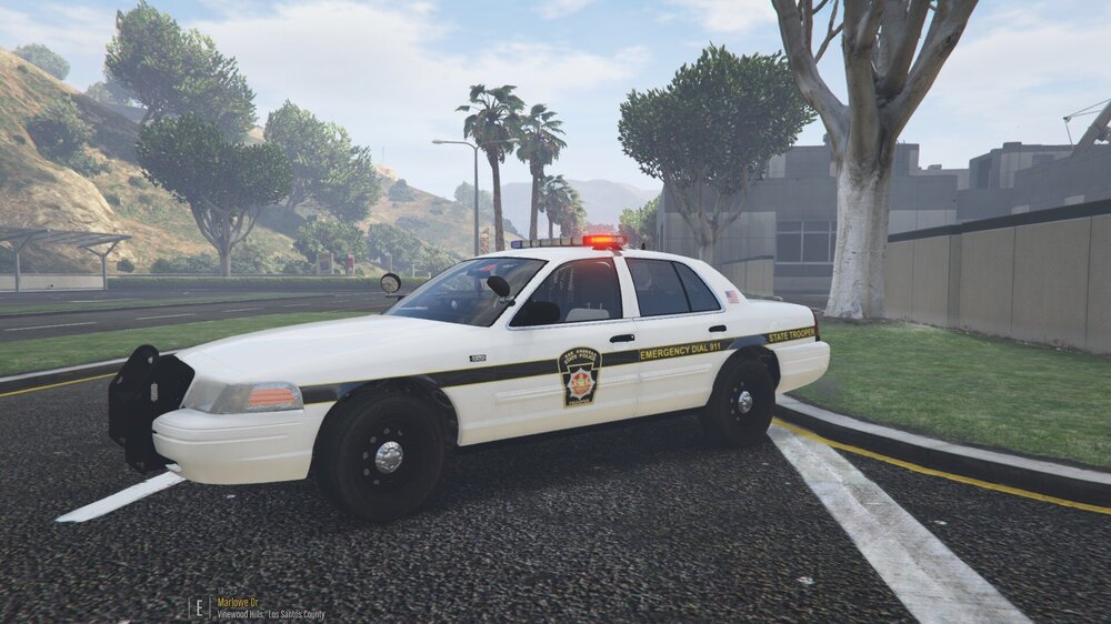 Could contain: vehicle, land vehicle, outdoor, sky, wheel, transport, tree, car, ford crown victoria police interceptor, tire, sedan, police car, full-size car, road, police, grass