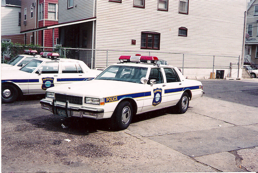 Could contain: vehicle, land vehicle, wheel, transport, outdoor, text, building, law enforcement, police car, emergency service, emergency vehicle, ford crown victoria police interceptor, vehicle registration plate, emergency, tire, police van, street, car, police, parked