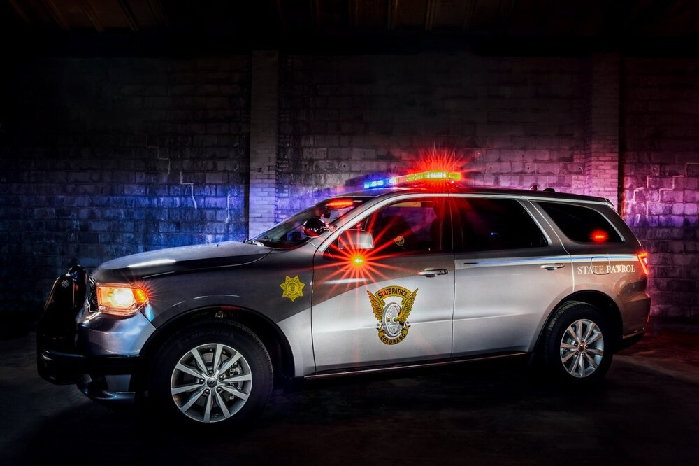 Could contain: land vehicle, vehicle, wheel, transport, car, tire, sport utility vehicle, auto part, bumper, roof rack, compact sport utility vehicle, crossover suv, automotive lighting, automotive exterior, automotive luggage rack, automotive carrying rack, police car, rim, ford, police, night, suv, light, parked