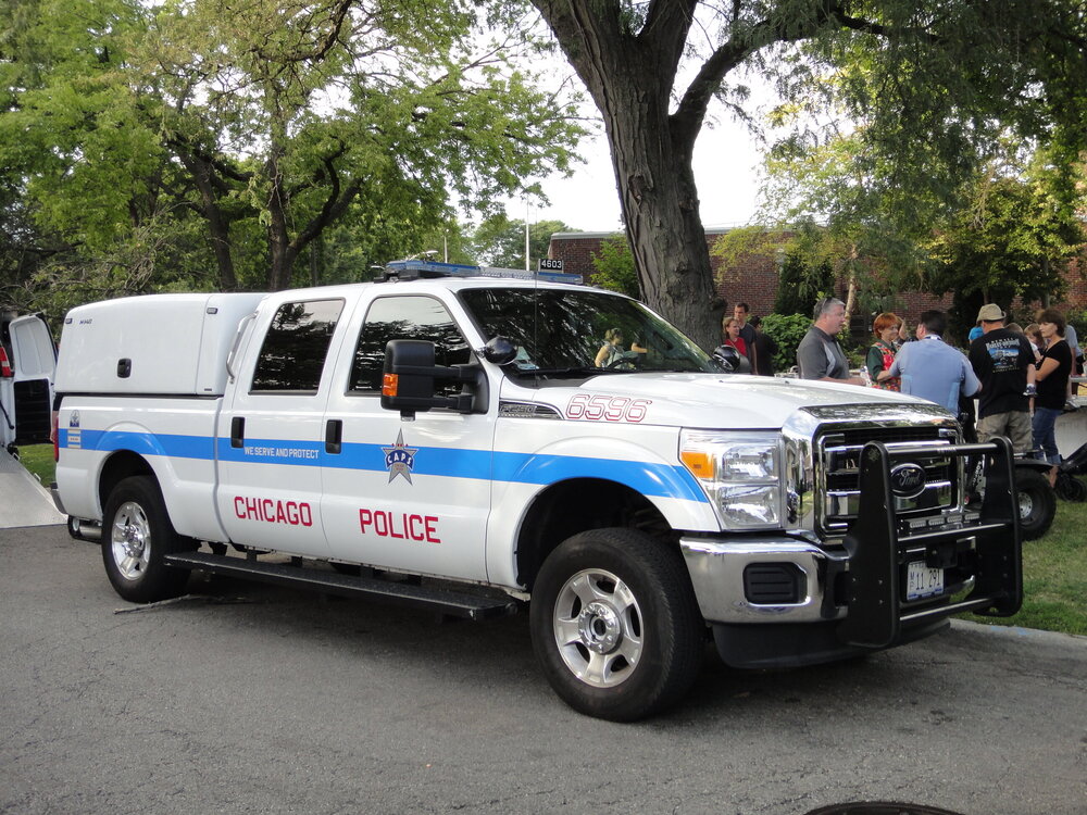 Could contain: land vehicle, vehicle, wheel, outdoor, police, transport, tree, tire, bumper, motor vehicle, auto part, law enforcement, automotive exterior, grille, general motors, emergency vehicle, car, ford, text, van, parked, truck