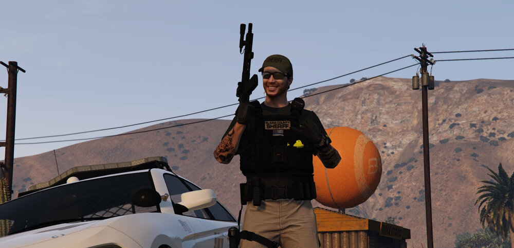 Could contain: outdoor, sky, person, clothing, vehicle, car, land vehicle, holding, orange, mountain, backpack, desert