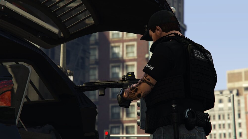 Could contain: person, clothing, outdoor, building, weapon, gun, firearm, man, rifle, city, street