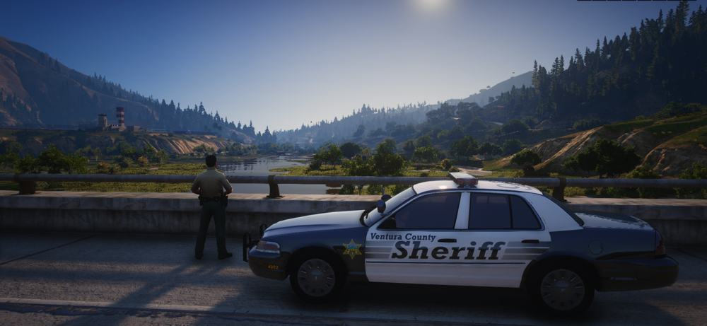 Could contain: vehicle, outdoor, land vehicle, transport, wheel, tire, sky, road, mountain, car, police, ground, parked