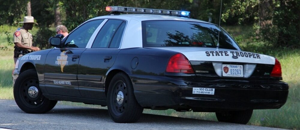 Could contain: land vehicle, vehicle, outdoor, text, wheel, transport, law enforcement, police car, police, vehicle registration plate, car, full-size car, ford crown victoria police interceptor, ford, tire, road