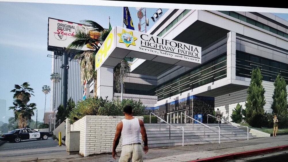 Could contain: outdoor, building, sky, billboard, tree, text, plant, advertising, sign, city, street