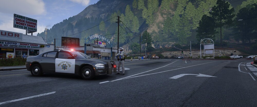 Could contain: outdoor, road, vehicle, land vehicle, sky, wheel, street, asphalt, cloud, text, mountain, lane, car, tire, tarmac, motor vehicle, tree, road surface, way, travel, sign, city, intersection