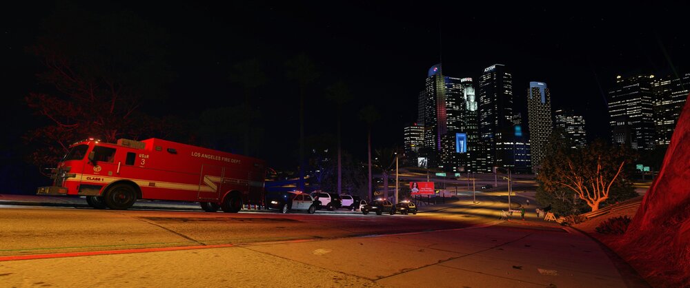 Could contain: vehicle, transport, outdoor, land vehicle, building, wheel, sky, skyscraper, van, firefighter, emergency service, road, night, red, ambulance, city, street, parked, light