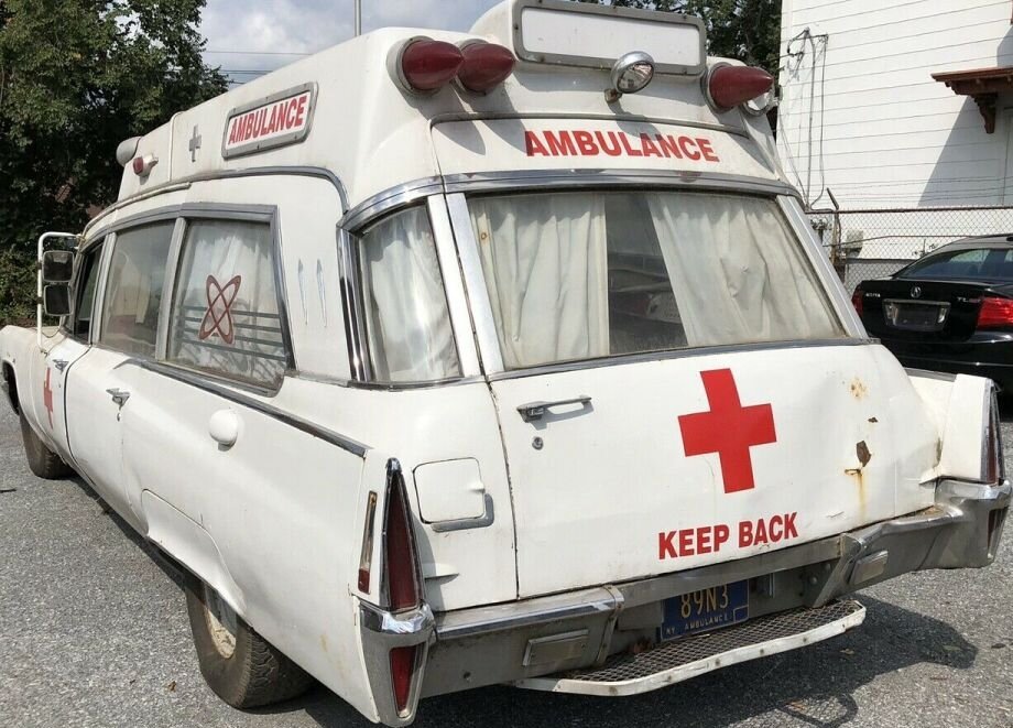 Could contain: vehicle, land vehicle, ambulance, text, outdoor, transport, wheel, car, vehicle registration plate, white, ground, parked, red