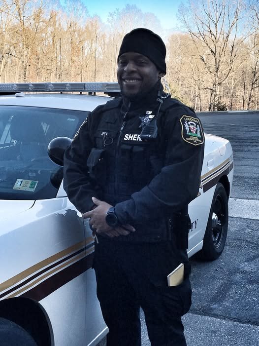 Could contain: vehicle, person, outdoor, clothing, land vehicle, tire, wheel, sky, car, law enforcement, man, auto part, human face, automotive exterior, police, officer