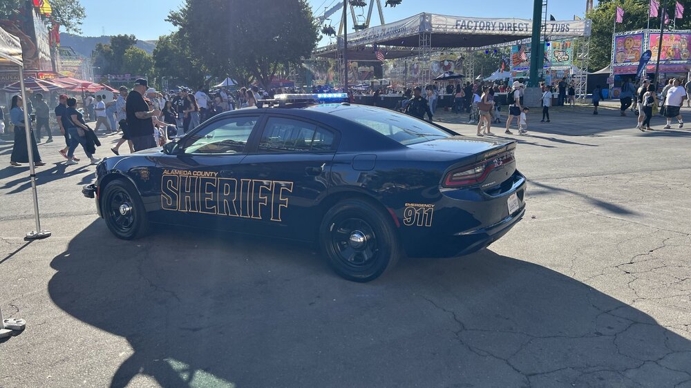 Could contain: vehicle, land vehicle, wheel, outdoor, sky, text, full-size car, car, mid-size car, tire, sedan, transport, sports sedan, road, ground, rally, crowd, street