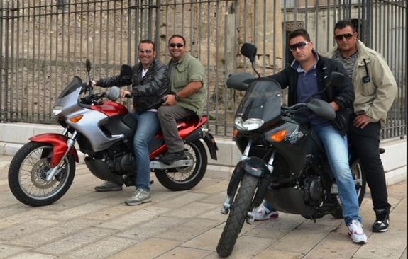 Could contain: vehicle, clothing, land vehicle, wheel, person, tire, outdoor, motorbike, footwear, man, brake, fuel tank, auto part, vehicle brake, building, jacket, cruiser, motorcycle fairing, motorcycle, fender, people, ground, riding, motorcycling, street, parked, bike